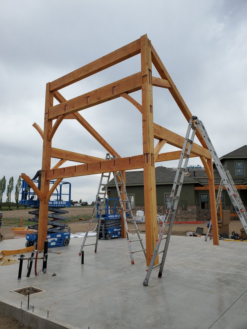Team installing heavy timber frame joinery for an outdoor barn project