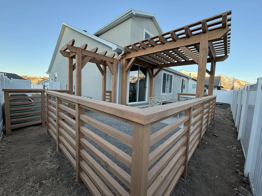 Backyard with a new timber deck and pergola attached to the home covering the patio