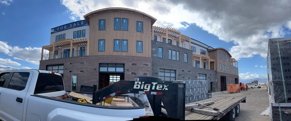 Construction site of a multi-story building in progress, featuring our timber frame pergolas, for this commercial project