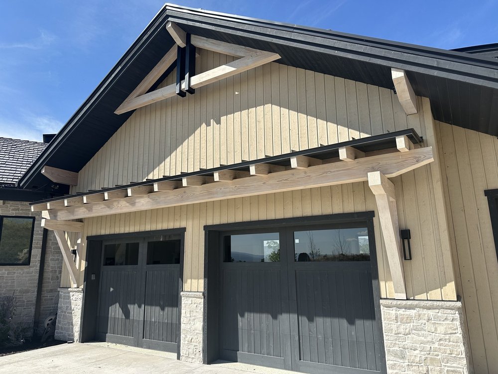 Exterior of a modern house with our exposed timber truss installed over the two-car garage
