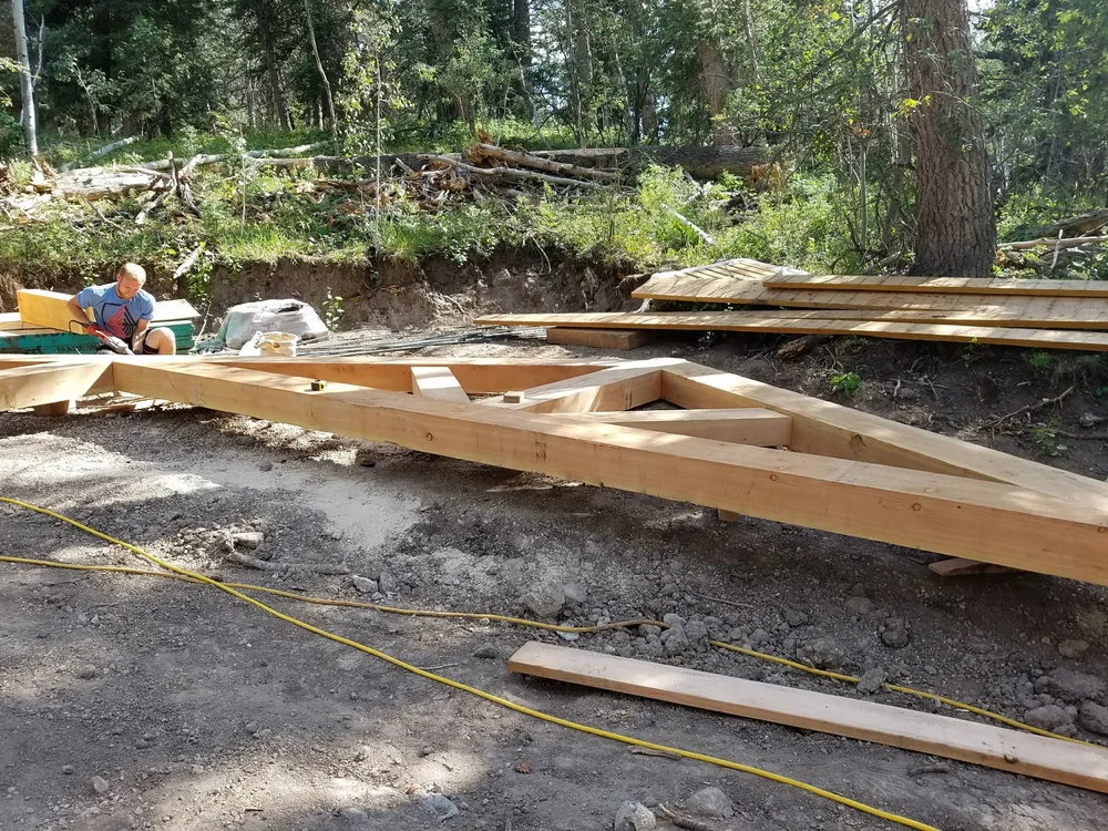 Team installing timber frames for an outdoor timber frame project