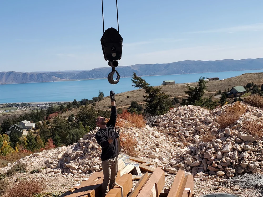 Team member lifting a timber frame to a crane for install