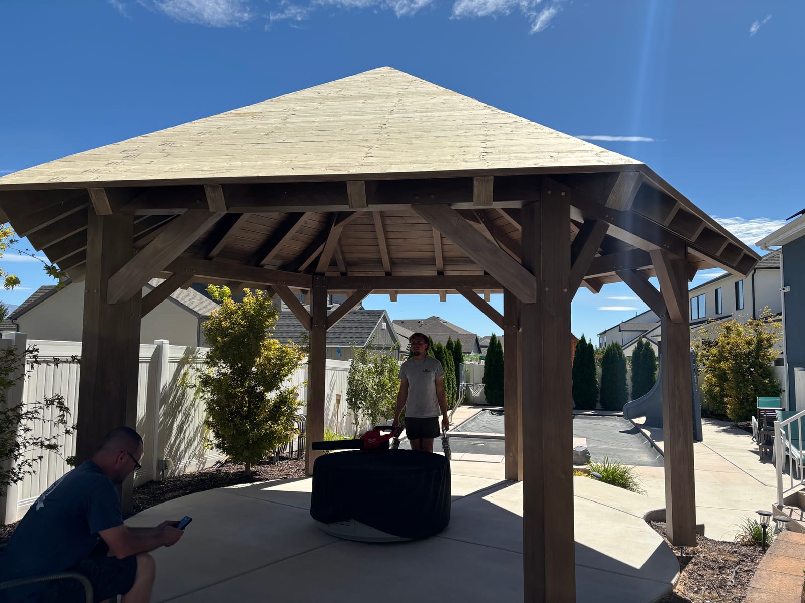Our team finishing a hip-roof timber pavilion in a client's backyard