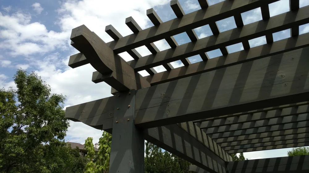 Layered timber pergola shading a backyard as a custom build for outdoor living.