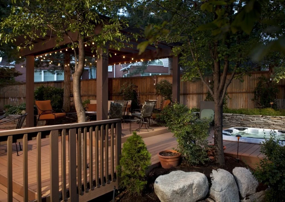 A backyard patio pergola with a covered seating area