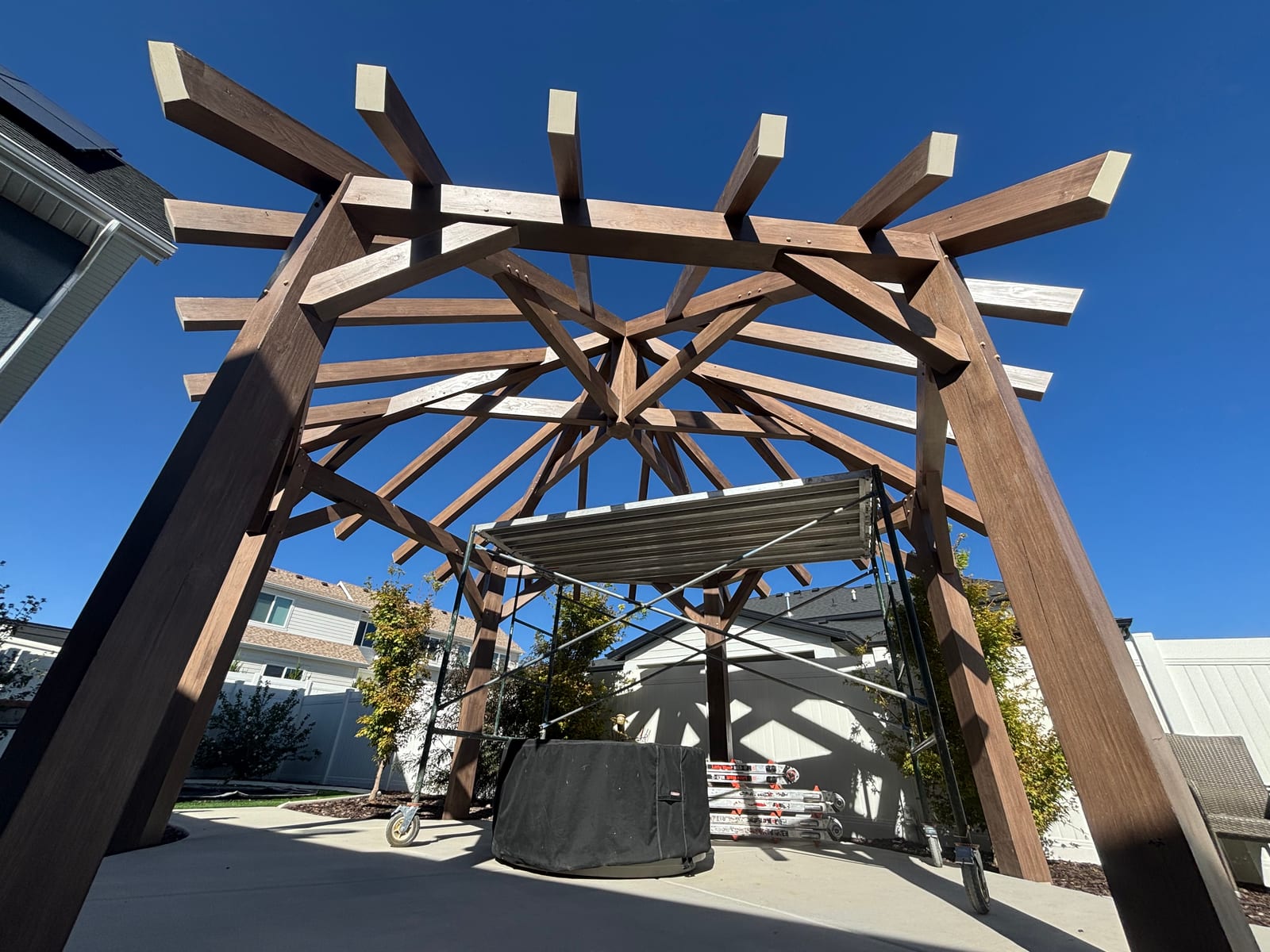 Radial timber pergola frame built over a backyard hot tub patio